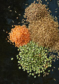 Lentils and grains of rice on a black background (ingredients for dog food)