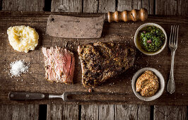 Roast beef with side dishes on a rustic wooden board