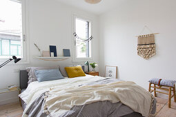 Schlafzimmer mit Doppelbett, Handarbeit an weißer Wand