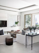White sofas, console table at back of sofa and terrace doors in bright living room
