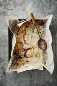 Baking paper on a baking tray with the remnants of a roast