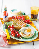 Tomato and rosemary skewers with a grilled bread roll and fried egg
