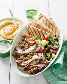 Stuffed lamb shoulder with pitta bread, hummus and salad