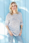 Junge blonde Frau in hellem Strickpulli