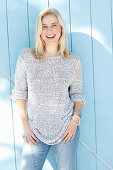 A young blonde woman wearing a light knitted jumper