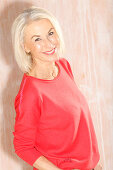 An older blonde woman wearing a red jumper