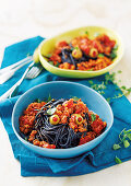 Black spaghetti with a minced meat sauce and olives