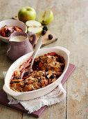 Apple and blackberry crumble with almond flakes