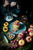 Pancakes with apple, honey, grapes, cinnamon and peach