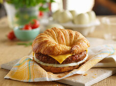 A croissant burger with cheese and egg