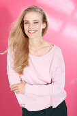 Junge blonde Frau in rosa Bluse