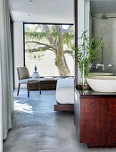 View into bedroom with concrete floor from ensuite bathroom