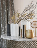 Gold, white and black vases and candle holders on table