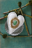 Green egg and golden wreath on fabric heart