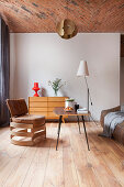 Designer-Lederstuhl, Coffeetable und Sideboard in offenem Wohnraum mit Ziegeldecke
