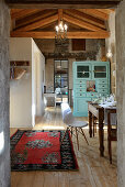 Antique dining table and classic chairs in converted barn with turquoise dresser in background used as partition