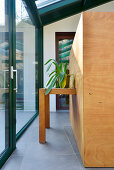 Houseplant on table integrated into wooden block in modern conservatory