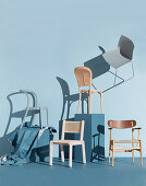 Various chairs in front of a blue-gray wall