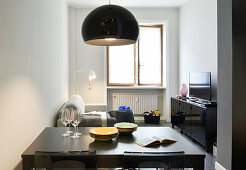 View over dining table into small living room with open window