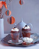 Coconut and chocolate cake in glasses with amarena cherries and cream