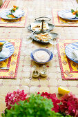 Red and yellow place settings on table with mosaic top