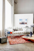 White cushion sofa on reddish carpet in front of window and wooden coffee table