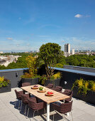 Braune Stühle um den Esstisch auf Dachterrasse mit Blick über London