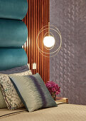 Pendant lamps in golden rings next to bed