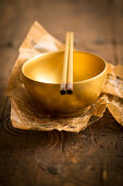A golden bowl with chopsticks