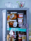 Various preserving jars in a kitchen cupboard