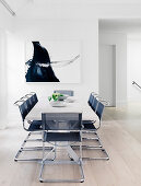 Designer cantilever chairs around white dining table in open dining area