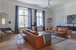 Two leather sofas facing one another in living room in shades of grey and brown