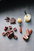 Zutaten für Eisbecher: Schokolade, Sahne, Kuchenstücke, Schokoriegel und Eis