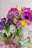 Lavish bouquet in glass vase and crocuses planted in pot