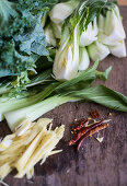 A still life of Asian ingredients with pak choi, kale, ginger and chili