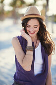 A young brunette woman wearing a hat and a purple mini dress