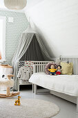 Grey canopy above cot in child's bedroom in grey and white