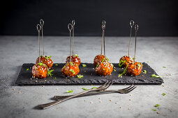 Meatballs with a Hoisin glaze and sesame seeds on skewers