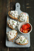 Wholemeal bread with cottage cheese with red radishes and scallion, cherry tomatoes