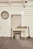 Drawer table on veranda with white painted wood paneling