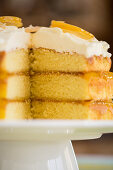 A three-layer lemon cake with frosting, sliced (close-up)
