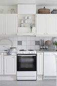 Old cooker in country-house kitchen decorated entirely in white