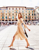 A young woman wearing an elegant, beige wrap-around dress