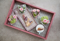 Kleine Blumensträußchen und Kuchen auf einem Tablett