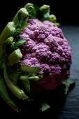 Purple cauliflower on a black slate countertop