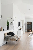 Fur blanket and cushions on bench against kitchen counter in open-plan interior