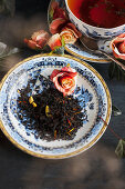 Tea leaves on a porcelain saucer, and a cup of black tea