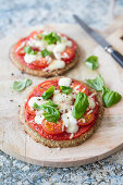 Low-carb pizza with a chickpea and sunflower seed base topped with tomatoes and vegan mozzarella