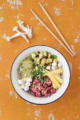 Poke bowl with tuna fish, avocado, broccoli shoots and enoki mushrooms on sushi rice (Hawaii)