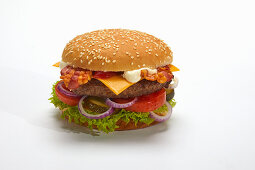 Ein Hamburger mit Speck und Käse vor weißem Hintergrund